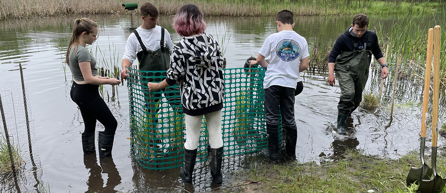 Local high school students plant wild rice as part of UW-Green Bay program.