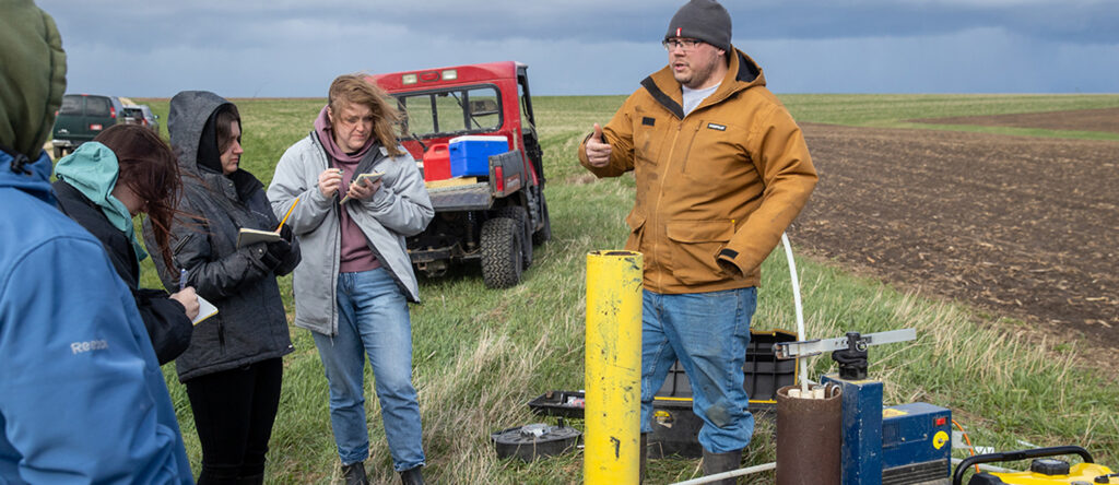 Students learn about the groundwater sampling network at Pioneer Farm and receive a demonstration on how to sample water from wells./ UW-Platteville